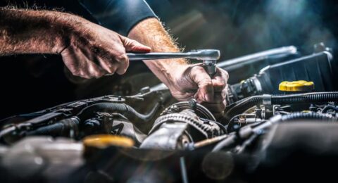 ASE certified mechanic performing repair services on car’s engine