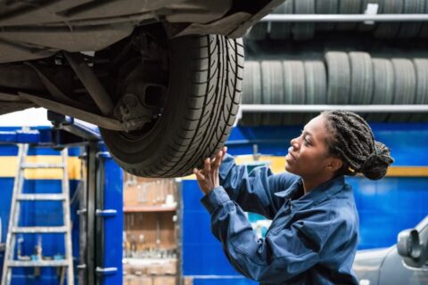 Young woman changing a car tire