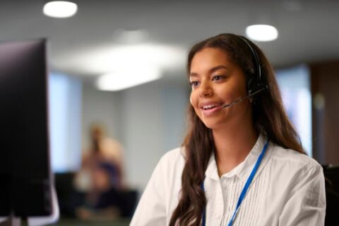 Young adult working at computer on headset