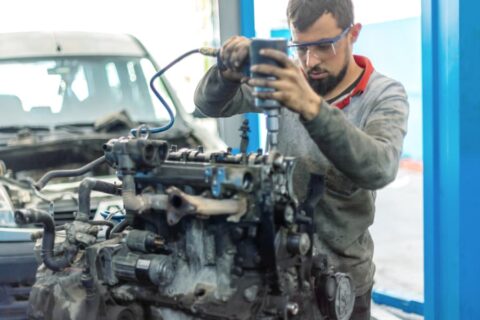 Young technician repairing vehicle engine